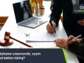 Dwie osoby przy biurku analizują dokumenty. Obok leży młotek sędziowski. Temat: windykator a komornik, czym się od siebie różnią?