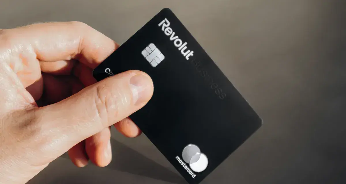 Dłoń trzyma czarną kartę Revolut Business. Nawet komornik nie zabierze Ci pieniędzy z tej karty.