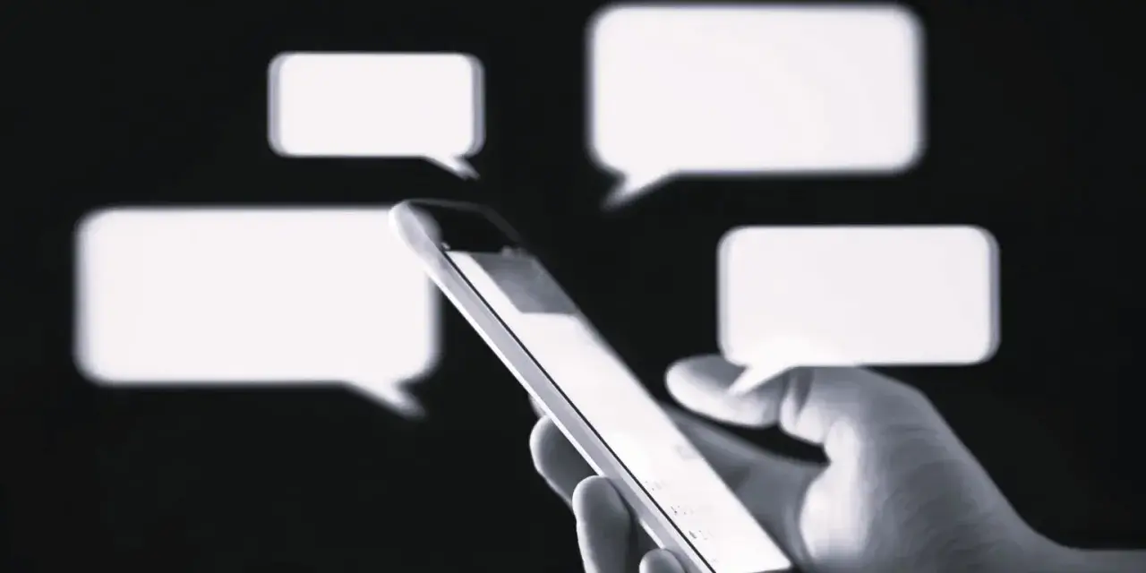 Dłoń trzyma smartfon, na ekranie którego pojawiają się dymki czatu. Czy to rozmowa o przedawnieniu długu?