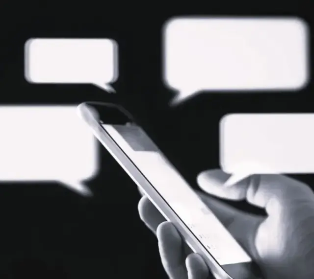Dłoń trzyma smartfon, na ekranie którego pojawiają się dymki czatu. Czy to rozmowa o przedawnieniu długu?